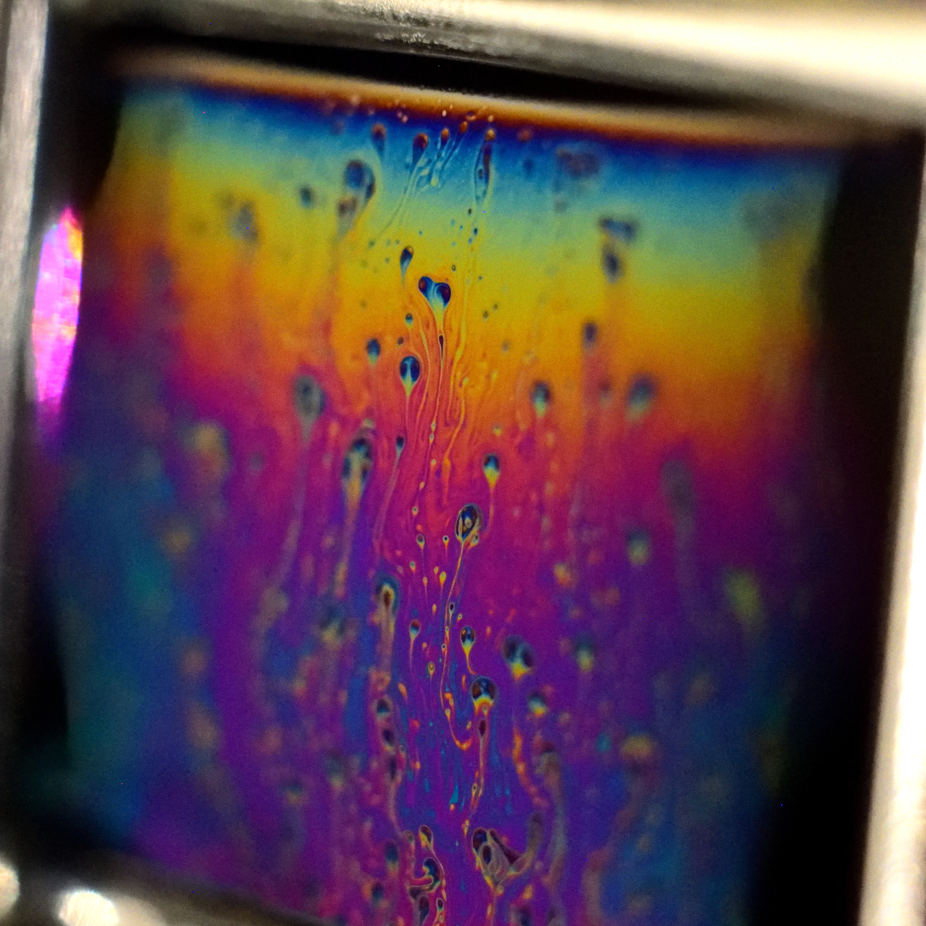 Turbulent flow within the draining of a thin soap film. Colours arise from interference within the thin film indicating differences in thickness.
